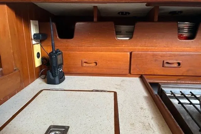 Slide: The Image of 1986 Tayana 37 yacht interior with wooden cabinetry and communication radio. - 27