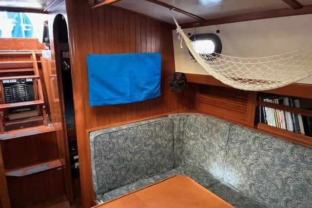 Slide: The Image of Interior of 1986 Tayana 37 sailboat with wood paneling and cozy seating area. - 29