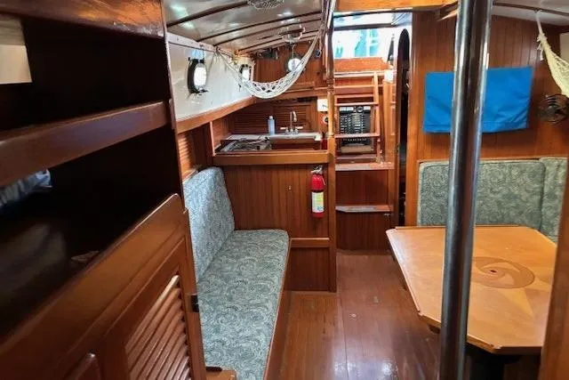 Slide: The Image of 1986 Tayana 37 yacht interior with wood finish, seating, and dining area. - 30