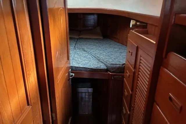 Slide: The Image of Cozy cabin interior of 1986 Tayana 37 sailboat with wooden furnishings and a comfortable bed. - 32