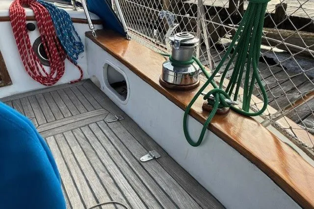 Slide: The Image of 1986 Tayana 37 sailboat deck with winch, ropes, and wooden trim. - 6