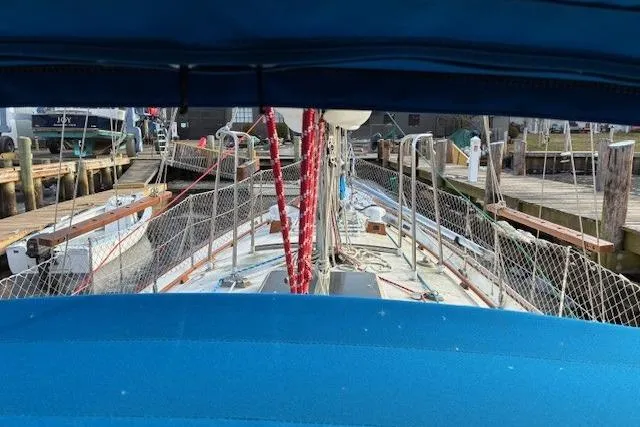Slide: The Image of 1986 Tayana 37 sailboat docked, view from cockpit with blue canopy and red ropes. - 9