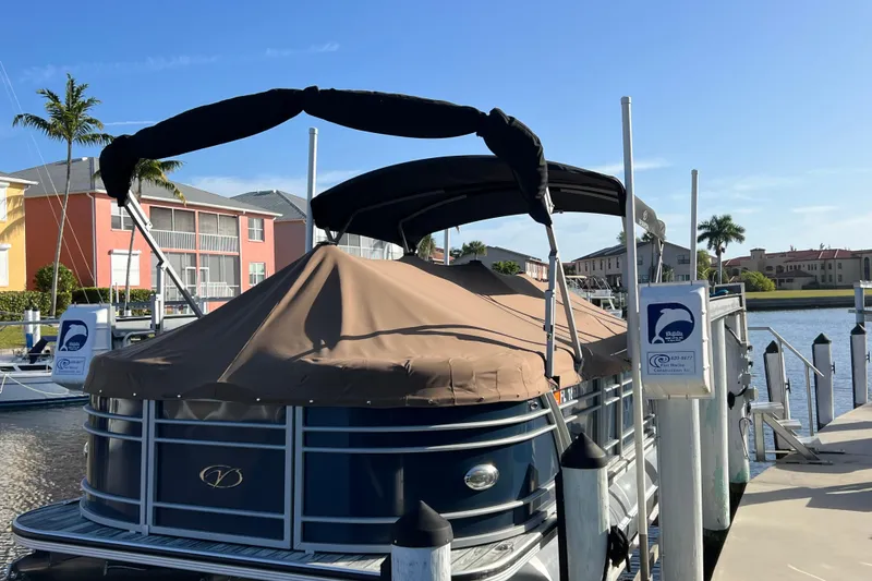 The Image of 2022 Veranda VP 25RC pontoon boat docked at a marina with covered seating. - 0