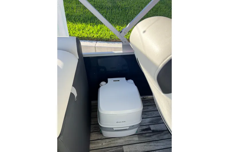 Slide: The Image of Portable toilet on 2022 Veranda VP 25RC boat deck, with seating and green grass background. - 17