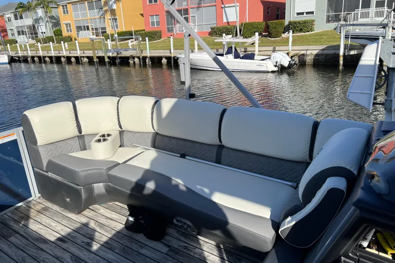 Slide: The Image of Luxurious seating on 2022 Veranda VP 25RC pontoon boat, docked by colorful waterfront homes. - 9
