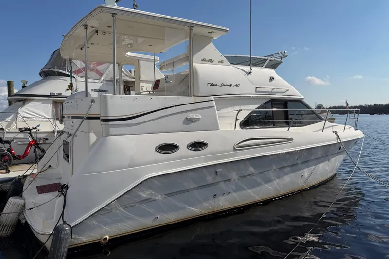 The Image of 1997 Sea Ray 370 Aft Cabin yacht docked on calm water under clear sky. - 0