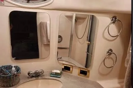 Slide: The Image of 1997 Sea Ray 370 Aft Cabin interior with white cabinetry and seating, docked by the water. - 10