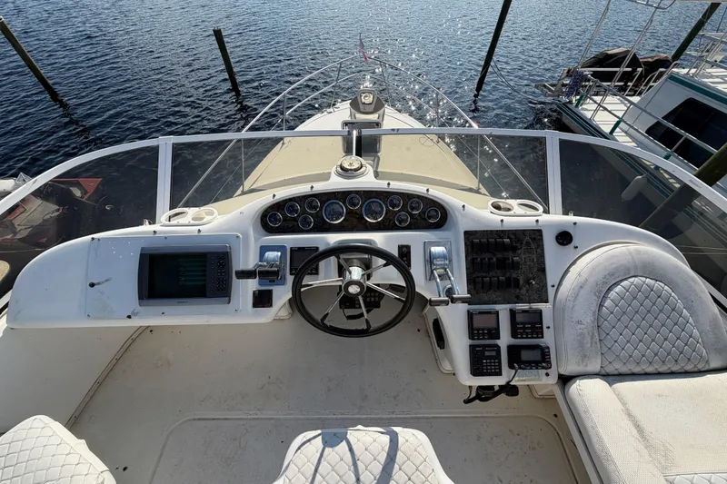 Slide: The Image of 1997 Sea Ray 370 Aft Cabin helm with steering wheel and navigation controls. - 27