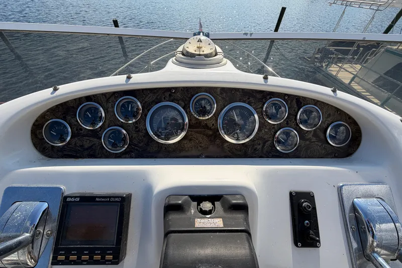 Slide: The Image of 1997 Sea Ray 370 Aft Cabin dashboard with gauges and controls, overlooking water. - 30