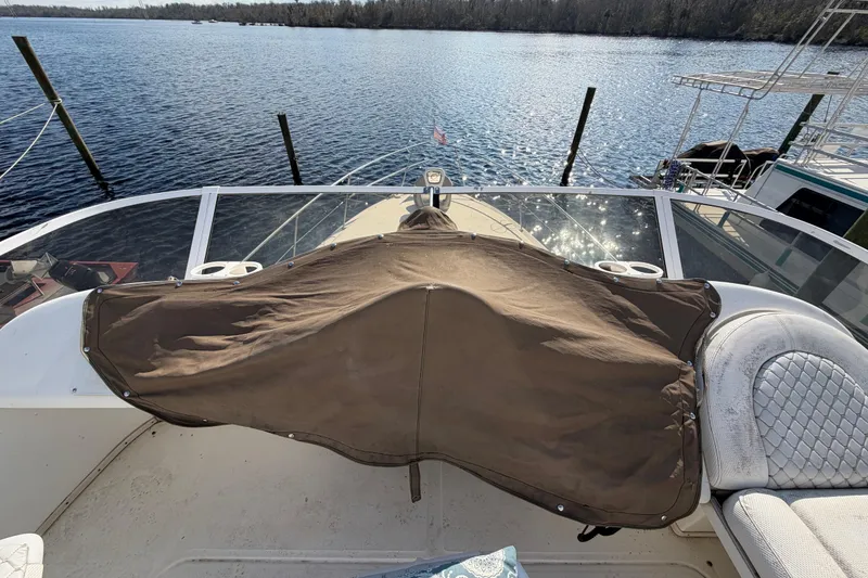 Slide: The Image of 1997 Sea Ray 370 Aft Cabin boat deck with covered equipment, overlooking serene water. - 39