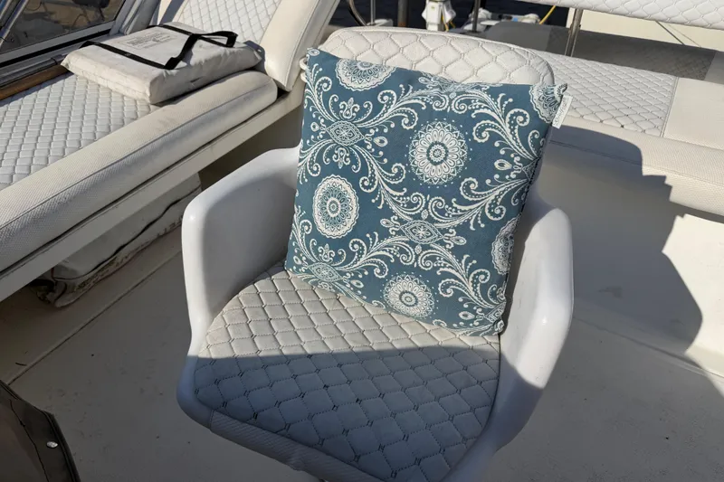 Slide: The Image of White cushioned seat with patterned blue pillow on 1997 Sea Ray 370 Aft Cabin boat. - 43