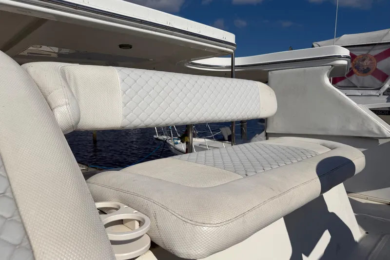 Slide: The Image of 1997 Sea Ray 370 Aft Cabin boat with white cushioned seating, docked by the water. - 45