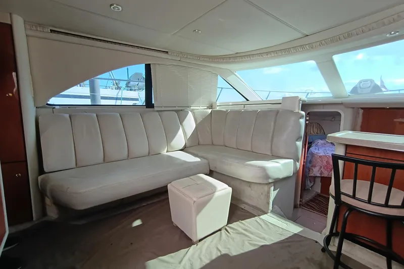 Slide: The Image of 1997 Sea Ray 370 Aft Cabin interior with plush seating and natural light. - 58