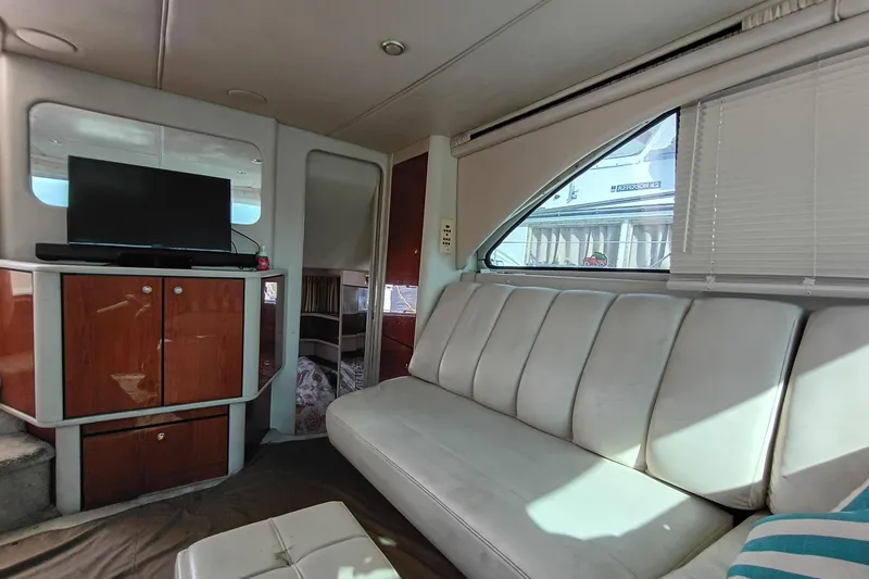 Slide: The Image of Interior of 1997 Sea Ray 370 Aft Cabin with sofa, TV, and wooden cabinetry. - 60