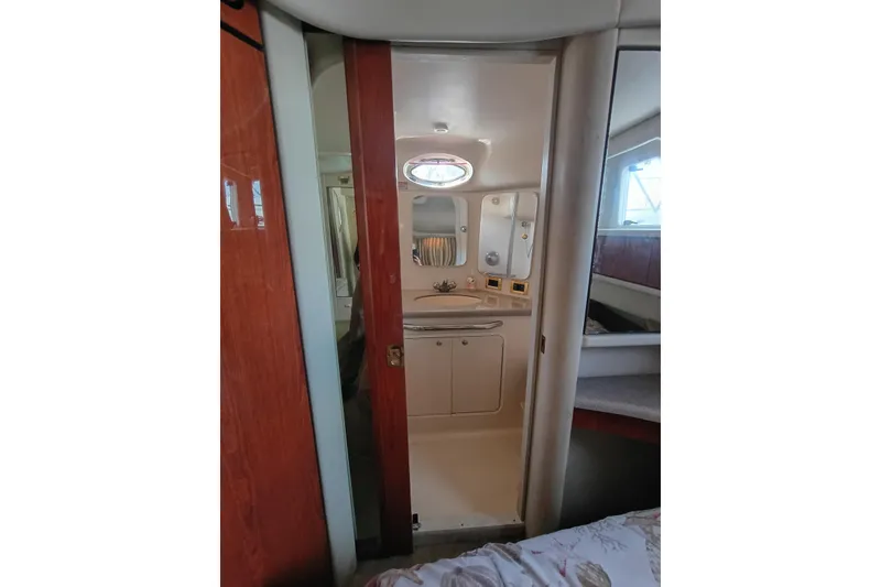Slide: The Image of 1997 Sea Ray 370 Aft Cabin interior with bathroom view, featuring sink and mirror. - 63