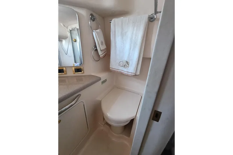 Slide: The Image of Bathroom interior of 1997 Sea Ray 370 Aft Cabin yacht, featuring a toilet and towel rack. - 64