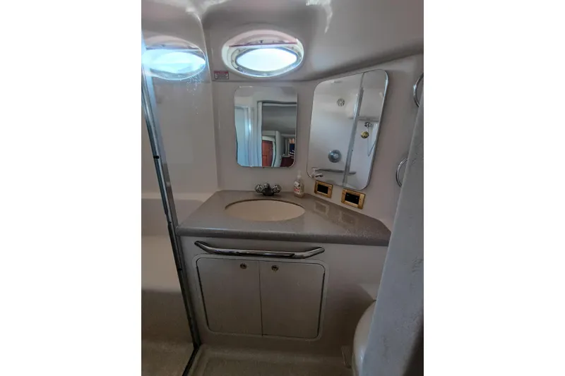 Slide: The Image of 1997 Sea Ray 370 Aft Cabin bathroom with sink, mirror, and storage cabinets. - 65