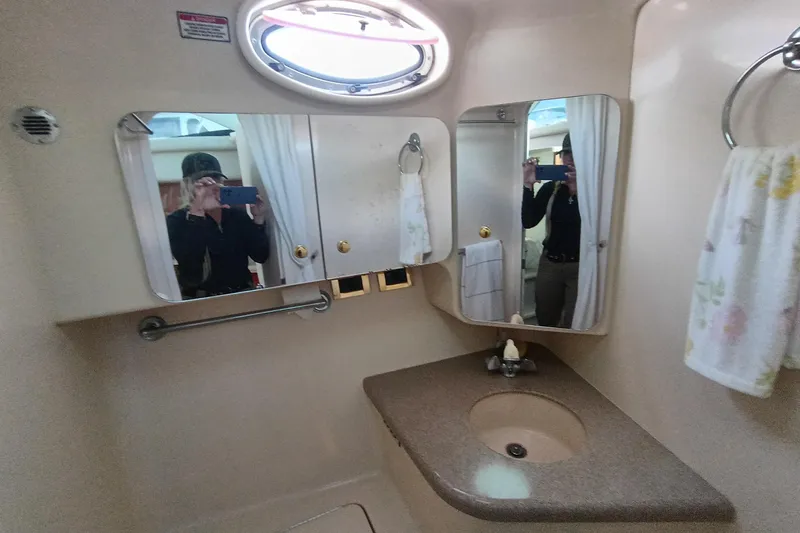 Slide: The Image of 1997 Sea Ray 370 Aft Cabin bathroom with mirror, sink, and towel rack. - 67