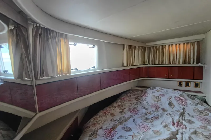 Slide: The Image of Cozy cabin interior of 1997 Sea Ray 370 Aft Cabin with patterned bedding and curtains. - 69
