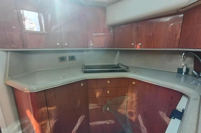 Slide: The Image of 1997 Sea Ray 370 Aft Cabin kitchen with wooden cabinets and modern appliances. - 74