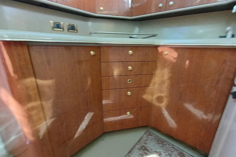Slide: The Image of 1997 Sea Ray 370 Aft Cabin interior with polished wood cabinets and drawers. - 77
