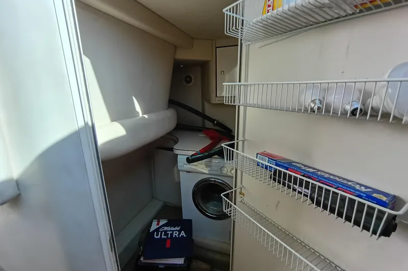 Slide: The Image of Laundry area in 1997 Sea Ray 370 Aft Cabin with shelves and washing machine. - 80