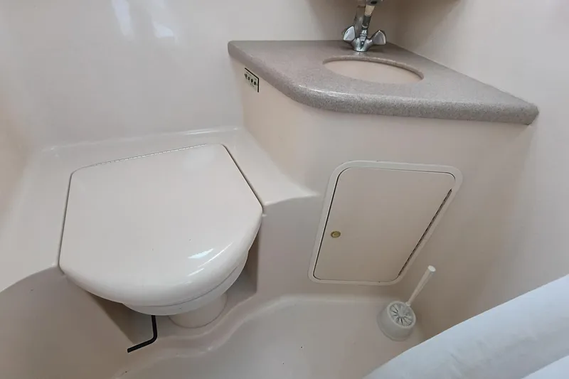 Slide: The Image of 1997 Sea Ray 370 Aft Cabin bathroom with toilet, sink, and storage compartment. - 86