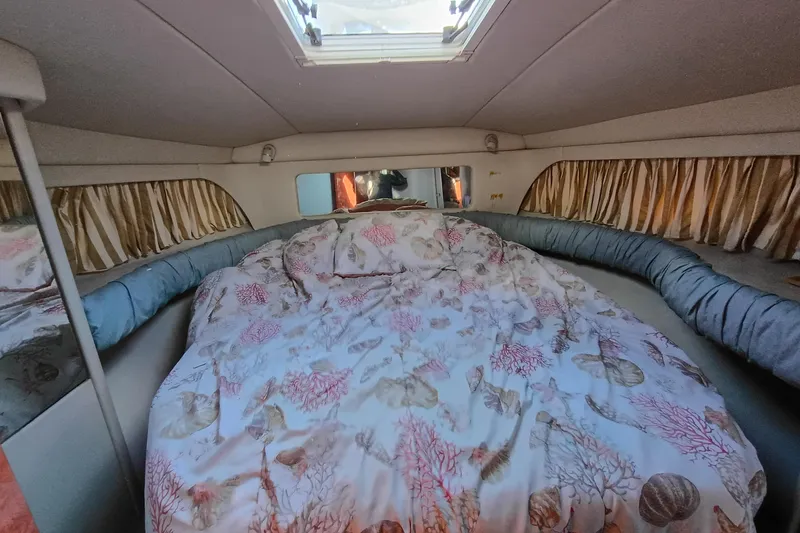 Slide: The Image of Cozy cabin interior of 1997 Sea Ray 370 Aft Cabin with patterned bedding. - 91