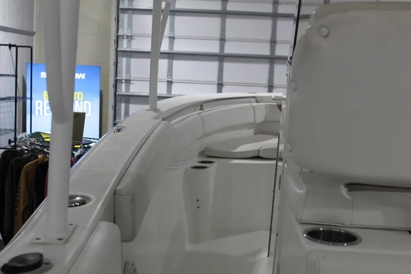 Slide: The Image of 2012 Sea Hunt Edge 24 boat interior with seating and cup holders in a showroom. - 15