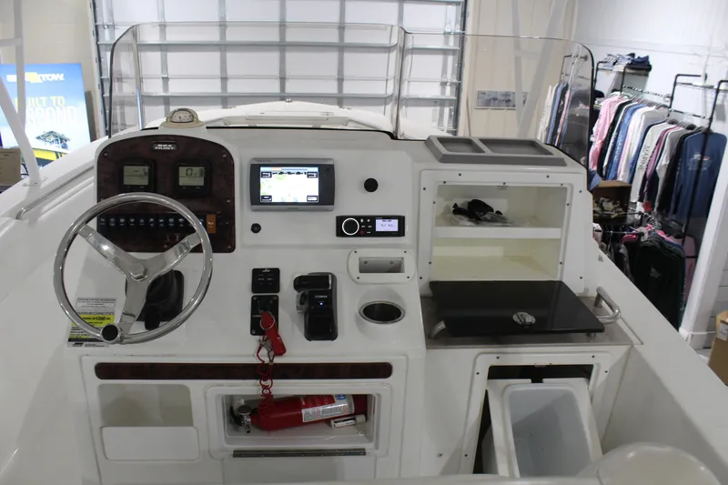 Slide: The Image of 2012 Sea Hunt Edge 24 boat dashboard with steering wheel, controls, and storage compartments. - 20