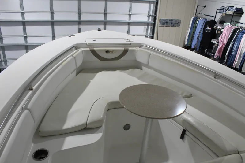 Slide: The Image of 2012 Sea Hunt Edge 24 boat interior with seating and table in a garage setting. - 26