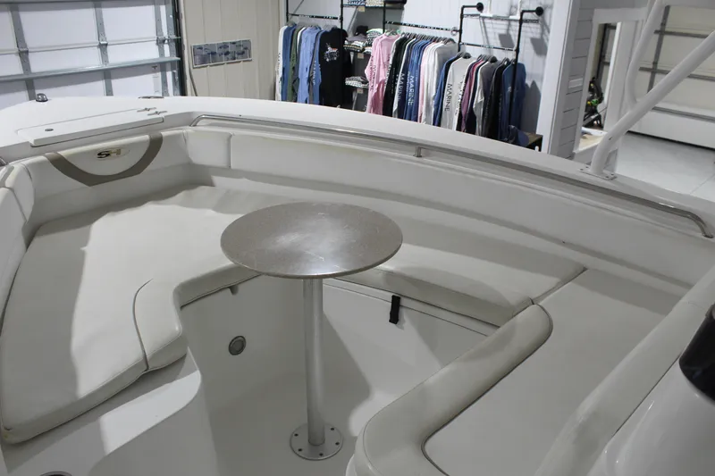 Slide: The Image of 2012 Sea Hunt Edge 24 boat interior with seating and table, garage setting. - 27