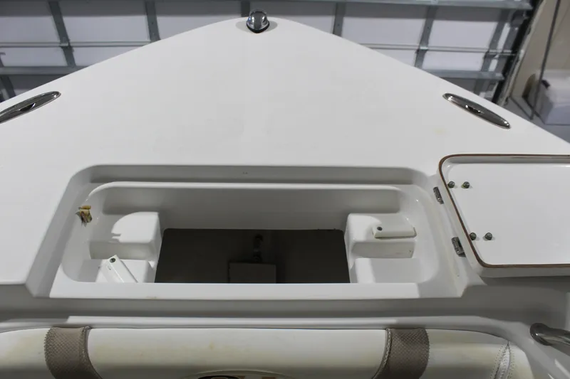 Slide: The Image of 2012 Sea Hunt Edge 24 boat interior storage compartment in a garage setting. - 32