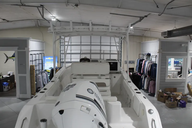 Slide: The Image of 2012 Sea Hunt Edge 24 boat displayed indoors, surrounded by clothing and accessories. - 6
