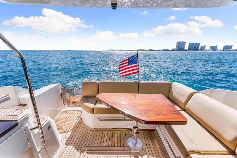 Slide: The Image of Luxurious 2016 Sea Ray 510 Fly yacht deck with seating, table, and ocean view. - 16