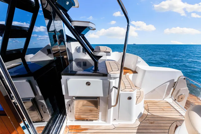 Slide: The Image of 2016 Sea Ray 510 Fly yacht deck with ocean view, featuring sleek design and modern amenities. - 18