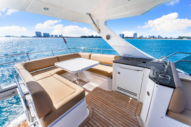 Slide: The Image of Luxurious 2016 Sea Ray 510 Fly yacht deck with seating, table, and ocean view. - 45