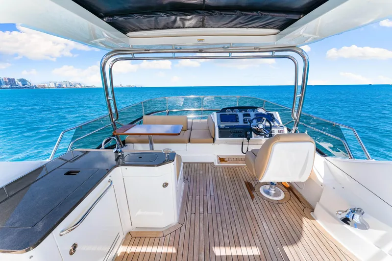 Slide: The Image of 2016 Sea Ray 510 Fly yacht helm with ocean view, featuring luxurious seating and controls. - 48