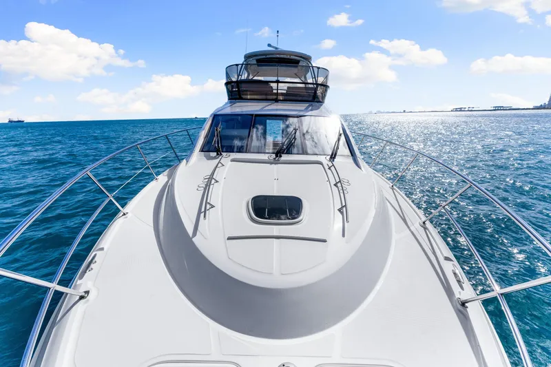 Slide: The Image of 2016 Sea Ray 510 Fly yacht cruising on open water under a clear blue sky. - 57