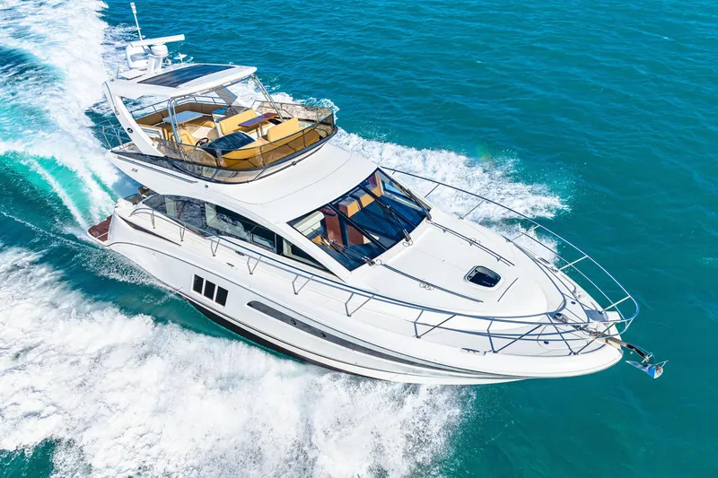 Slide: The Image of 2016 Sea Ray 510 Fly yacht cruising on clear blue ocean waters. - 6