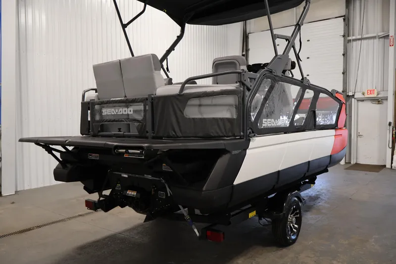 Slide: The Image of 2024 Sea-Doo Switch Cruise 18 pontoon boat in a showroom, rear view. - 4