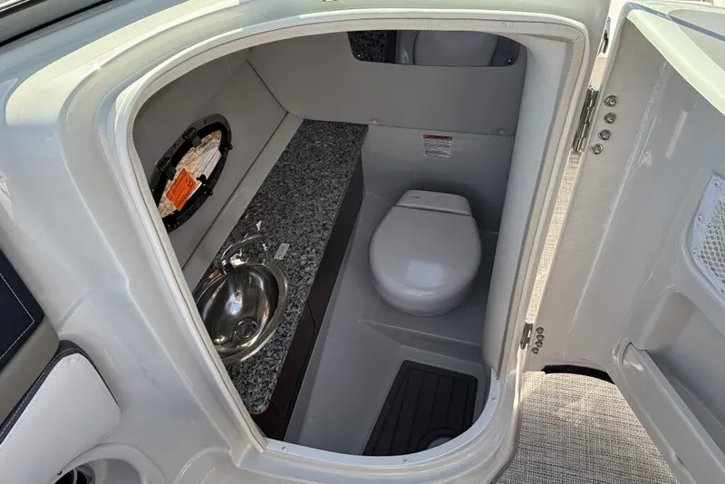 Slide: The Image of 2026 Crownline Eclipse E260 XS boat interior bathroom with sink and toilet. - 6