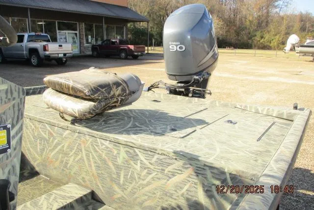 Slide: The Image of 2006 Lakesport 1860 CC boat with Yamaha 90 engine, camo design, outdoor setting. - 2