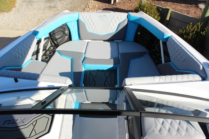 Slide: The Image of 2026 Tigé 24RZX boat interior with blue and gray seating, cup holders, and quilted design. - 21