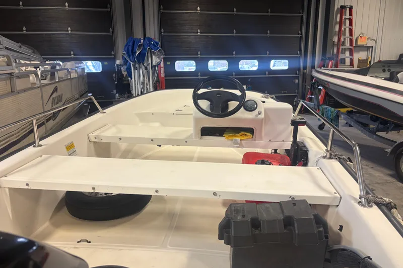 Slide: The Image of 2001 Boston Whaler 130 Super Sport boat interior in a garage setting. - 3