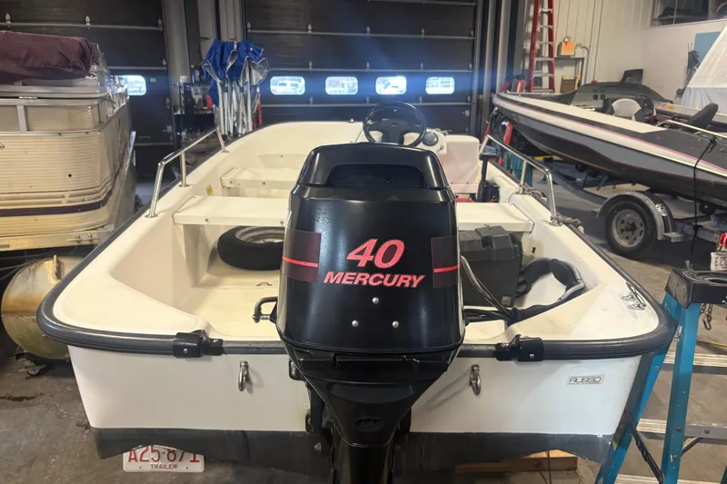 Slide: The Image of 2001 Boston Whaler 130 Super Sport with 40 Mercury engine in a garage setting. - 4
