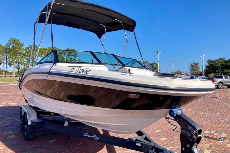 Slide: The Image of 2017 Sea Ray 19 SPX OB boat on trailer with canopy, parked on brick pavement. - 2