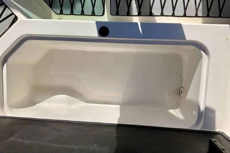 Slide: The Image of 2017 Sea Ray 19 SPX OB boat storage compartment, white interior, open lid. - 21