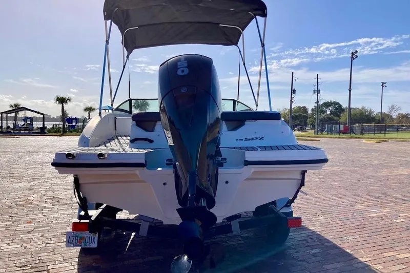 Slide: The Image of 2017 Sea Ray 19 SPX OB boat with outboard motor, parked on brick pavement under clear sky. - 5