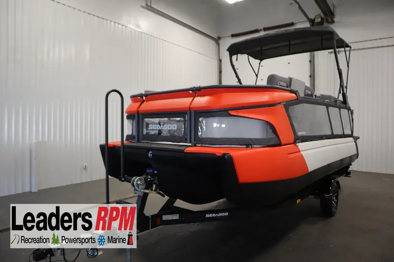 The Image of 2024 Sea-Doo Switch Cruise 21 in a showroom, featuring a vibrant orange and black design. - 0